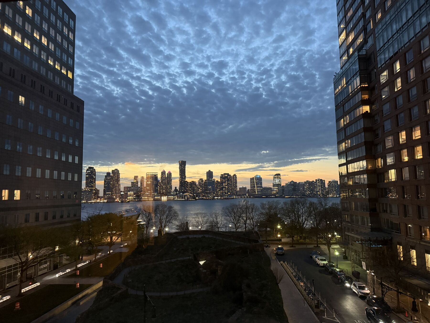 A city skyline at dusk seen between two towers